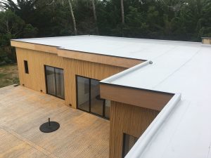 maison en bois avec toit plat et membrane blanche