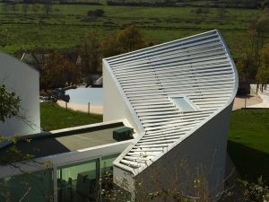 maison d'architecte avec toit plat au milieu et membrane grise