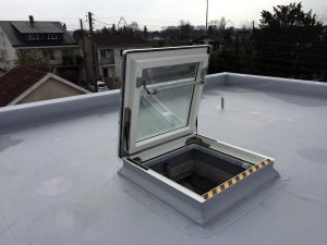 toit plat avec membrane blanche et lanterneau d'accès